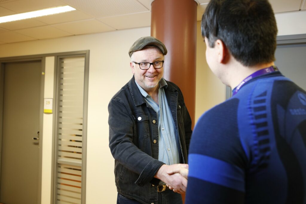 Mies kättelee Etelä-Hämeen työllisyysalueen työntekijää.