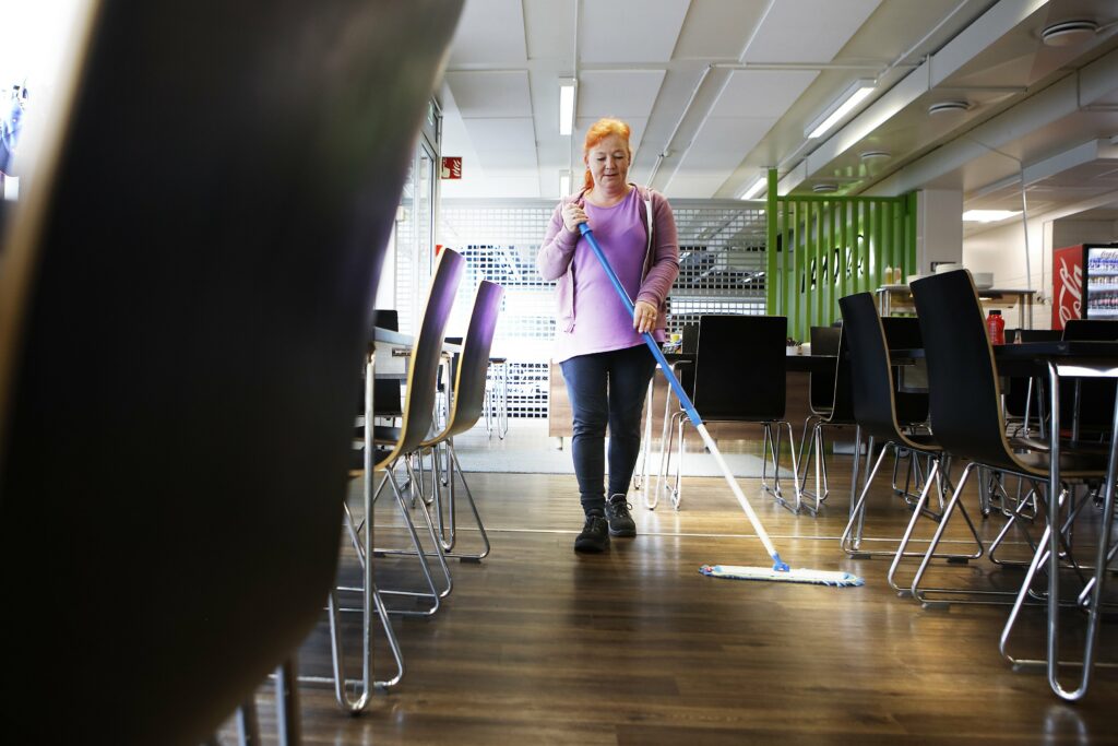 Siivooja moppaa ravintolan lattiaa.